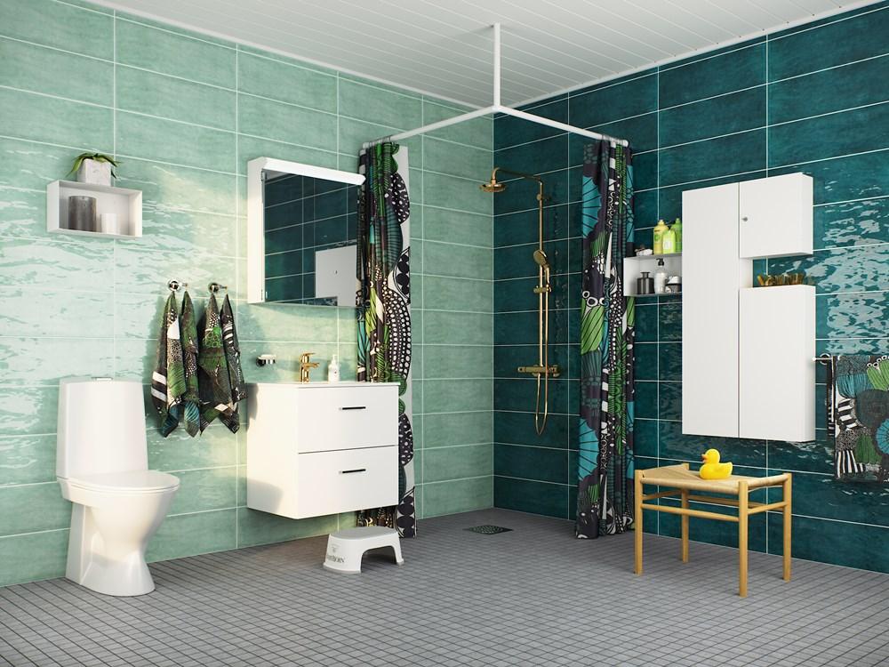 Kylpyhuone, jossa valkoiset kalusteet vihreällä seinällä